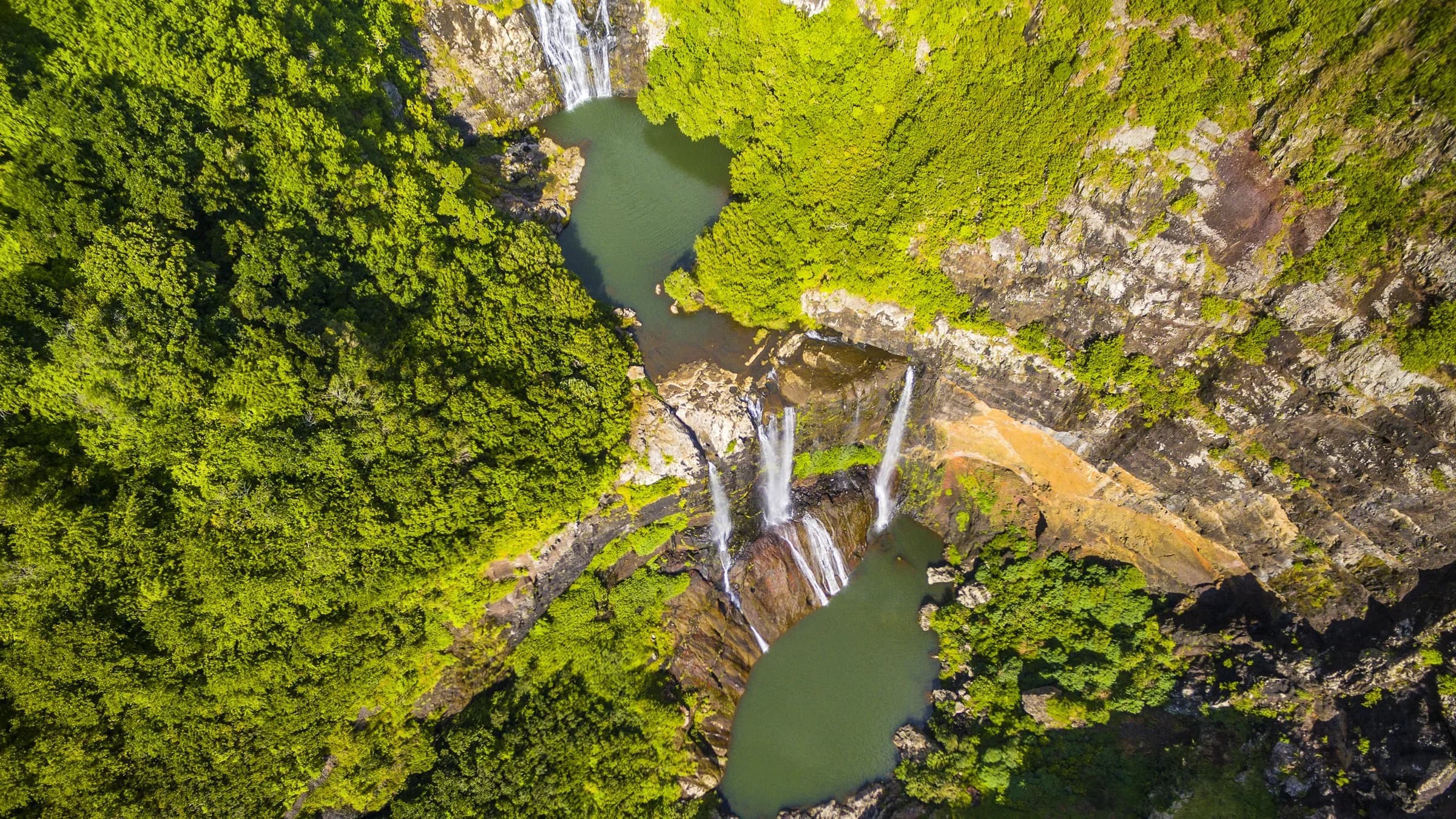 Aerial view of Tamarind Falls cascading through a deep green volcanic gorge