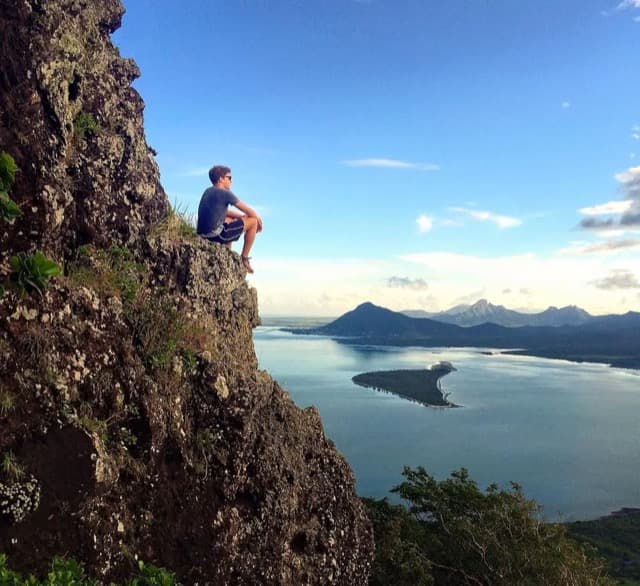 Hiker sitting above the lagoon on Le Morne Brabant, Mauritius